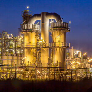 Detail of a heavy Chemical Industrial plant with mazework of pipes in twilight night scene